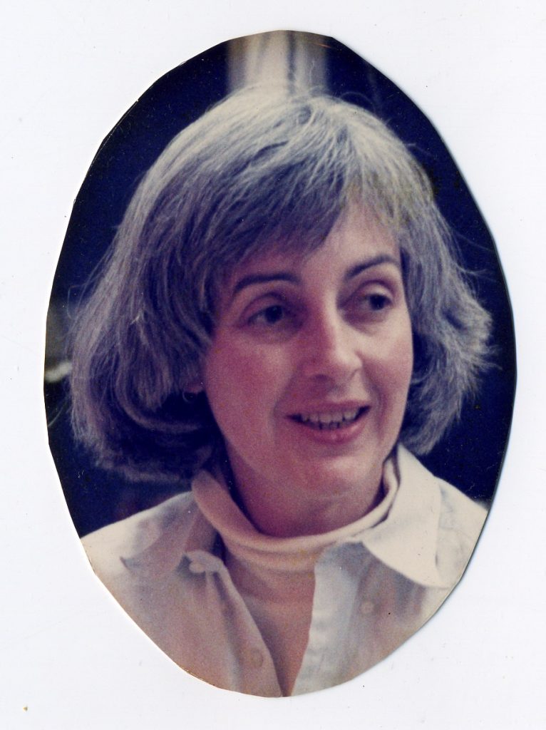 Headshot of a smiling woman with chin-length graying hair
