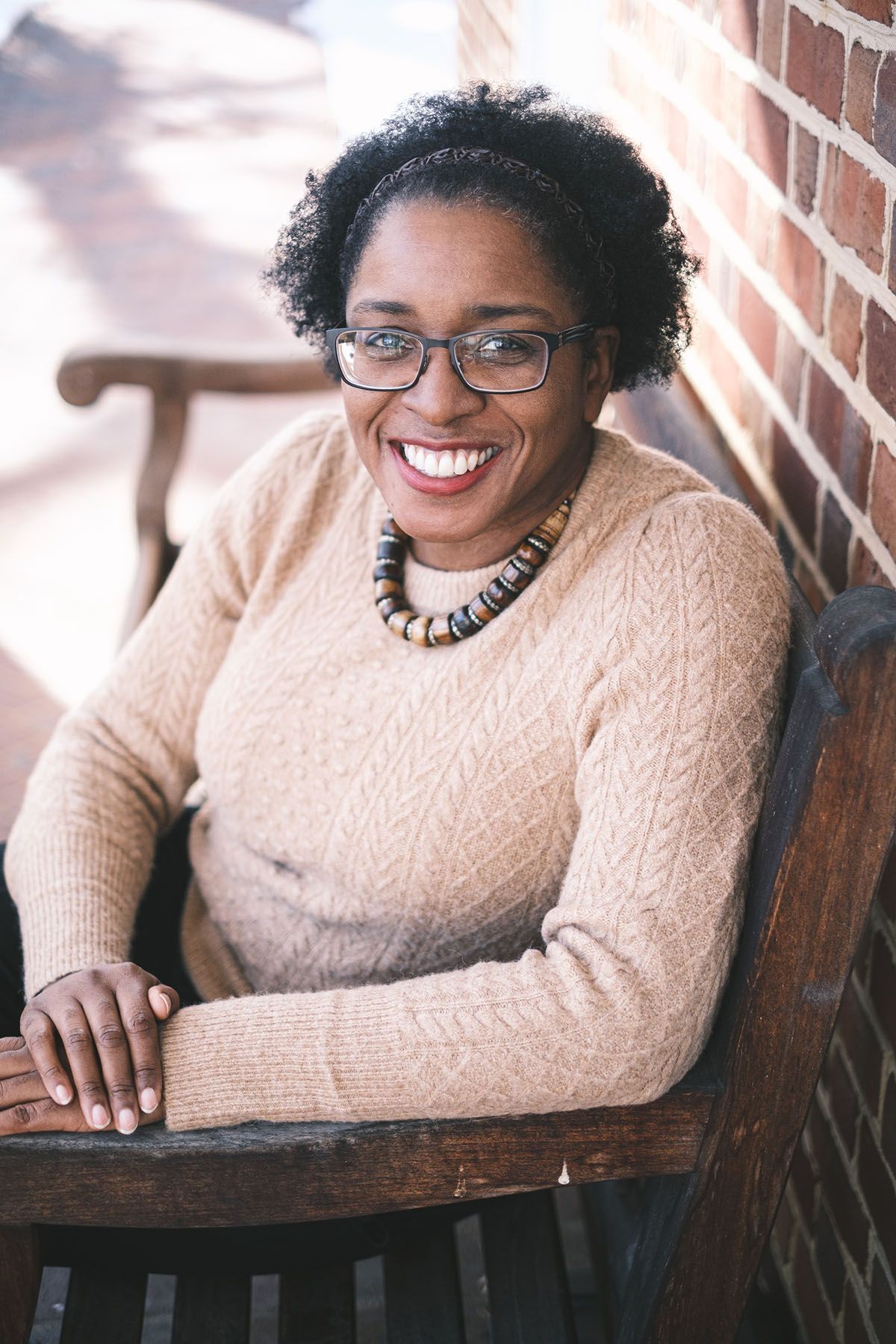 Headshot of a smiling Black woman with glasses and a necklace