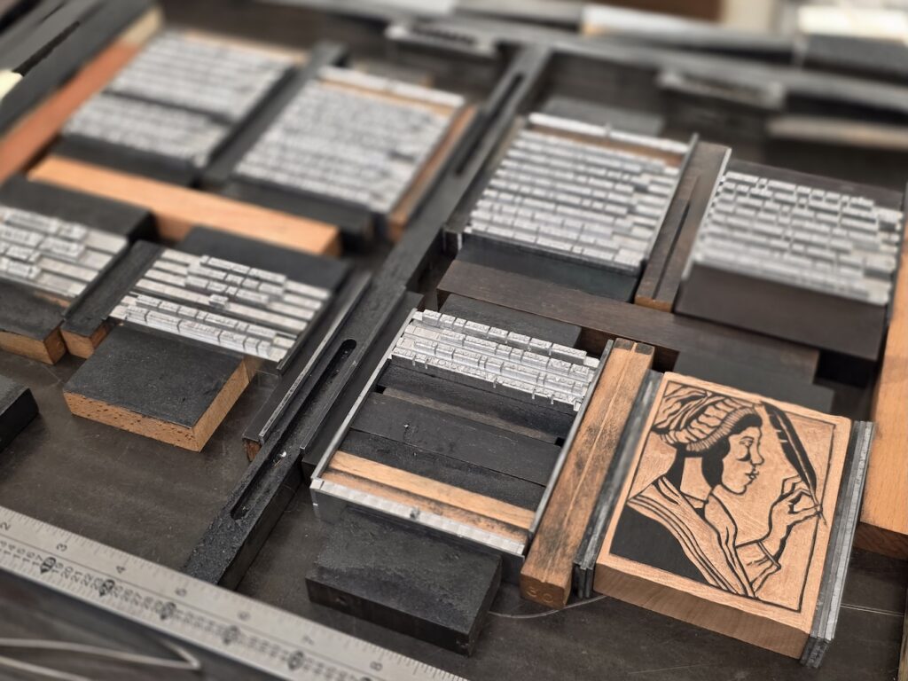 Close-up of a lock-up of type with lines of lead type and a woodcut image of Phillis Wheatley in a bonnet with a quill pen